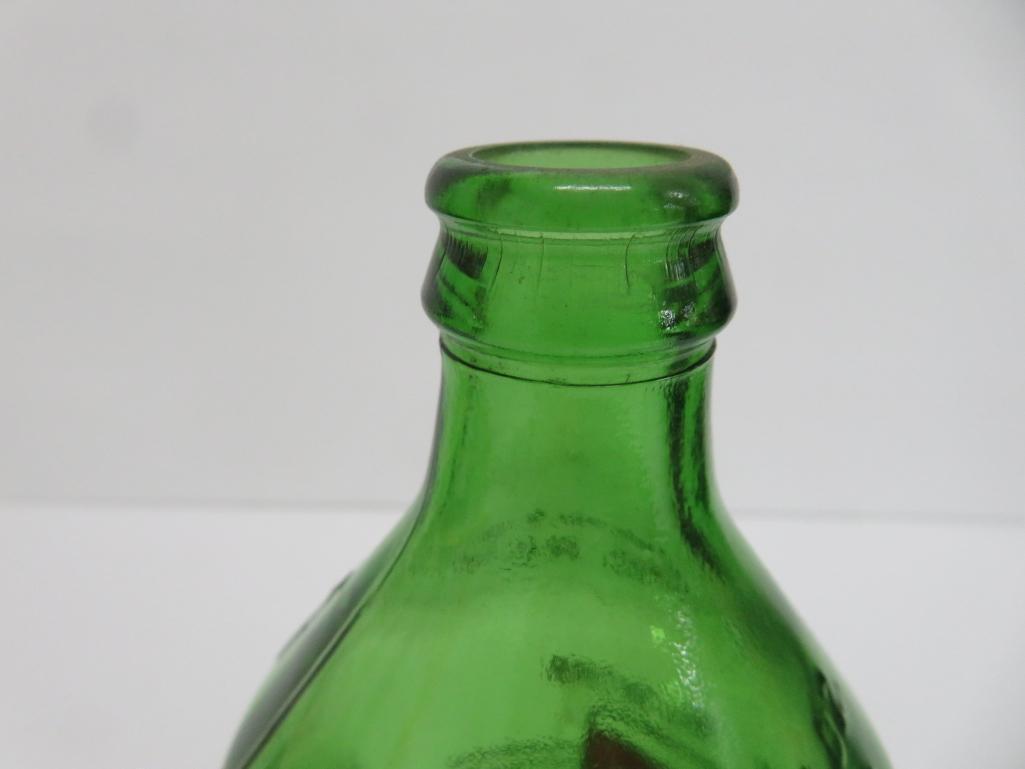 Seven assorted types and sizes of vintage 7 up bottles and paper carrier