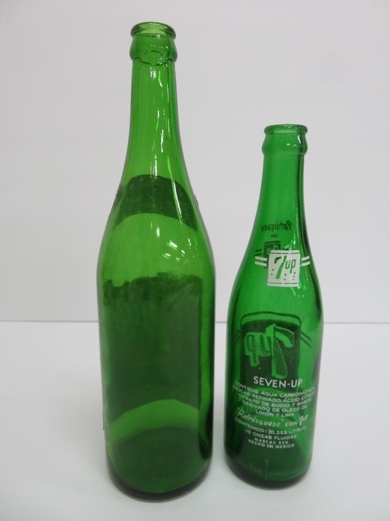 Seven assorted types and sizes of vintage 7 up bottles and paper carrier