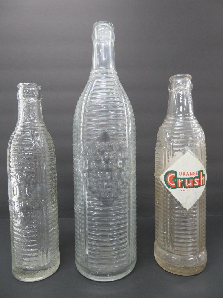 Three clear ribbed Orange Crush Bottles