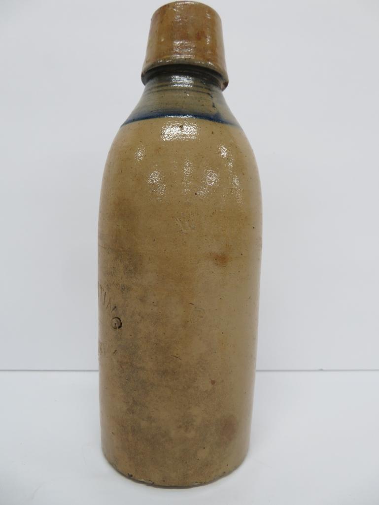 El Husting Milwaukee Stoneware bottle with blue band, 8"