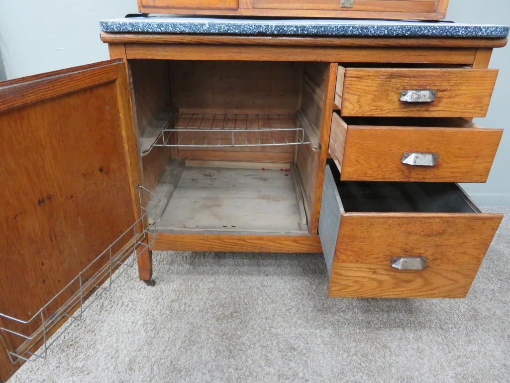 Oak Hoosier cabinet with flour bin and enamel top