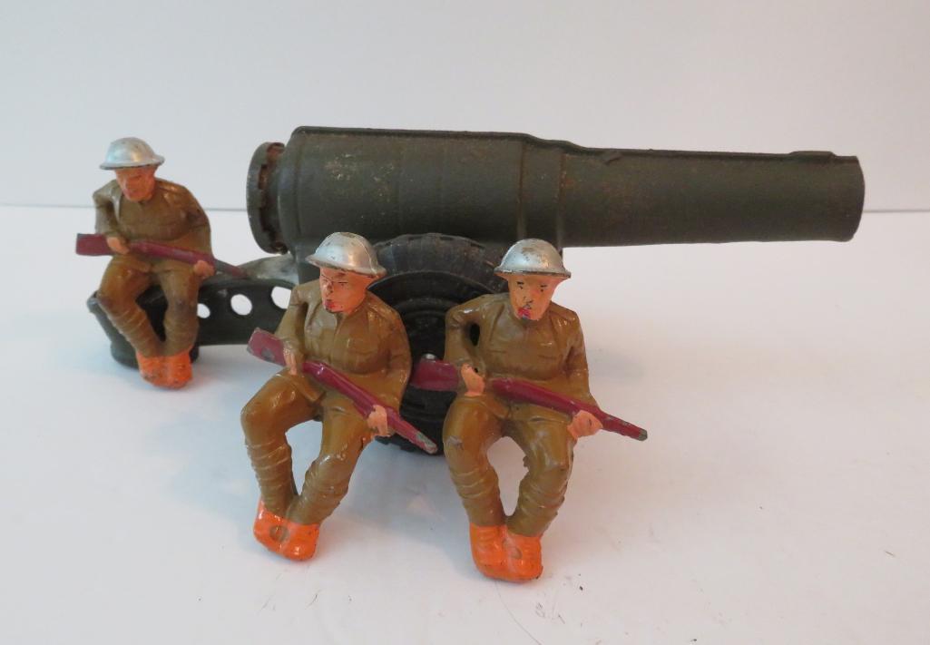 Cast iron carbide cannon and three seated soldiers