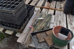 Assortment of bamboo sticks and plastic plant trays, located in GH 24