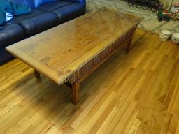 Coffee table-all wood w/ ornate side carving, glass top. 68"L x 27"W x 20" H