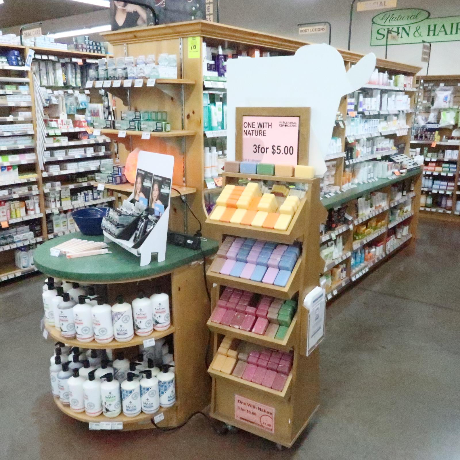 wooden merchandising island, one side is mirrored w/ glass shelves