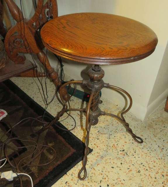 antique piano stool with cast metal legs and oak seat