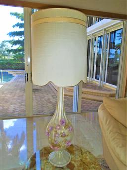 Glass base table lamp with pink glass flower decoration.