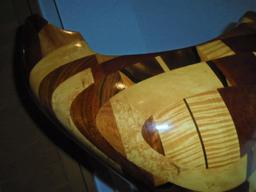 Large curvy shaped wood sculpture on a wood base.