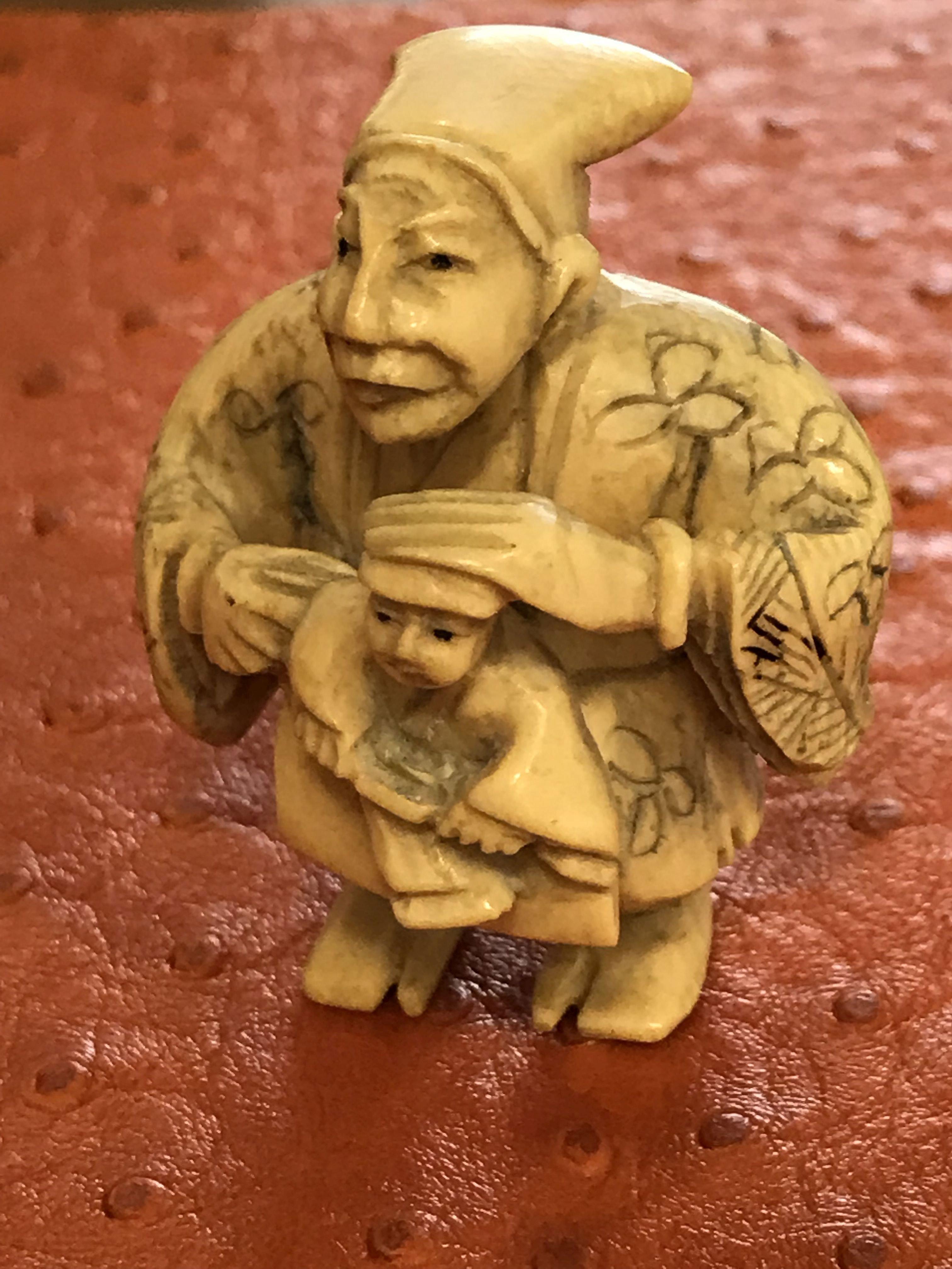 Antique Chinese timeless beautifully designed small ivory bone carved figurine of a man with child a