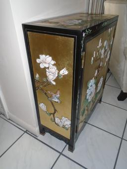 Black and gold painted cabinet with floral and bird motif.