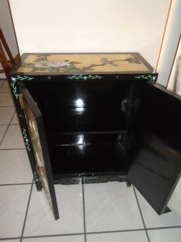 Black and gold painted cabinet with floral and bird motif.