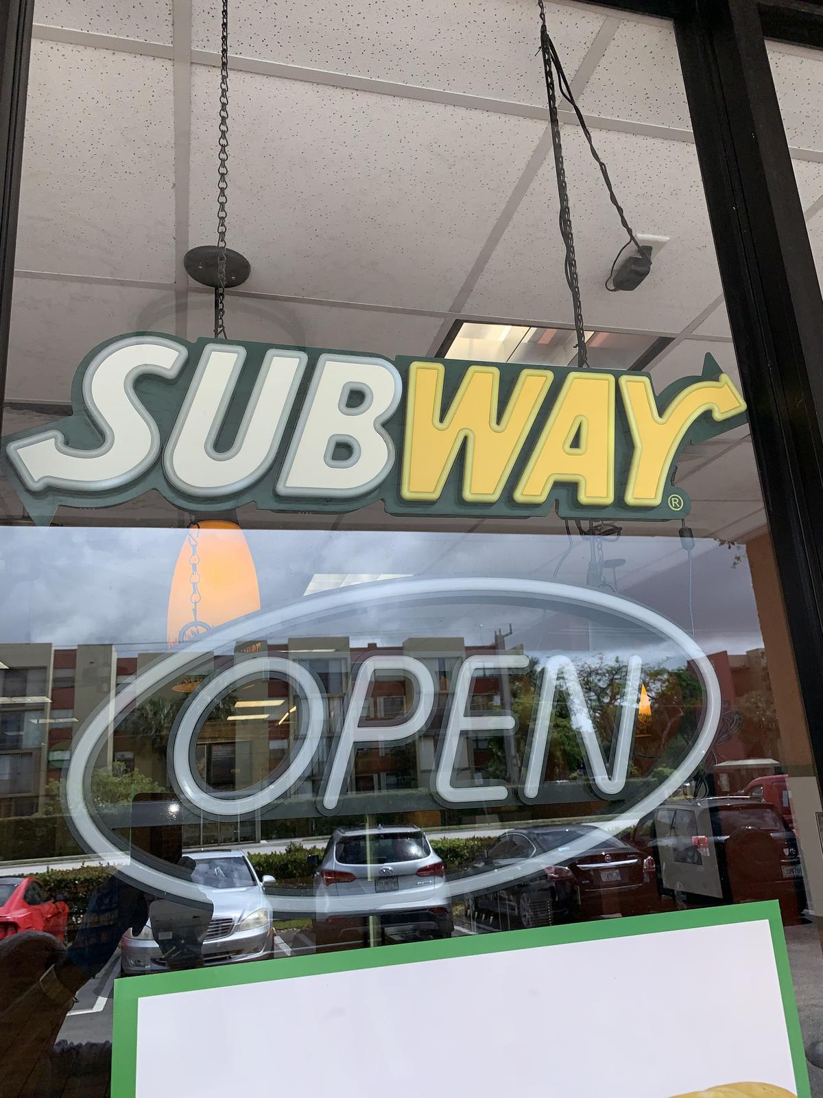 Neon "OPEN" sign with "SUBWAY" attached