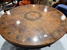 Round Dining Table with black design inlay and carved wood base with black and gold leaf