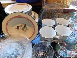 Collection of Christmas dishes and glasses with linens and candleholders
