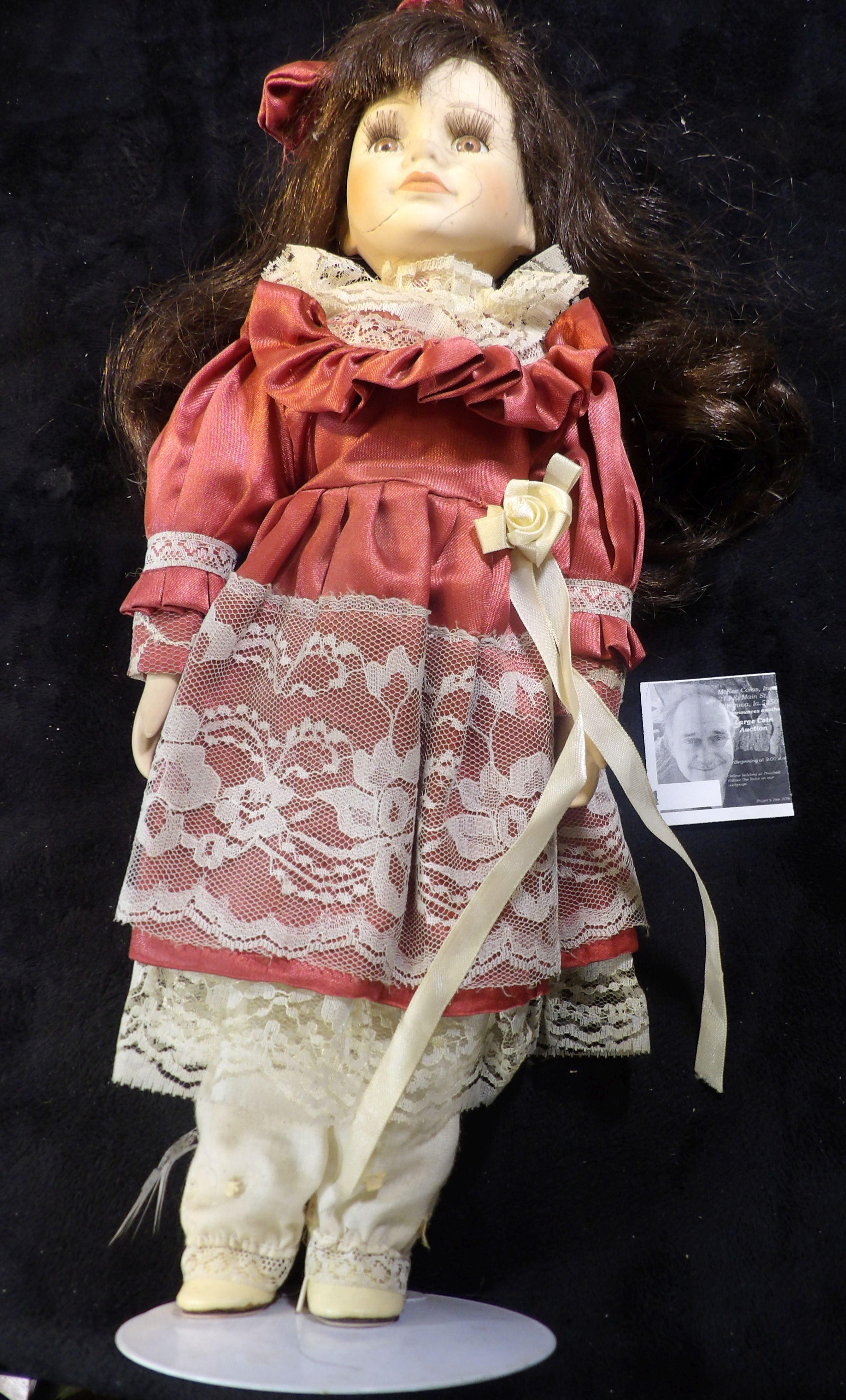 Female Doll on stand in a lace costume with bow in her hair. 15" tall.