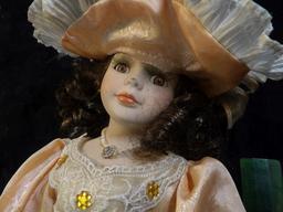 Lovely Brown-haired female Doll with lace Dress and hat, on stand. A little over 14" in height. Carr