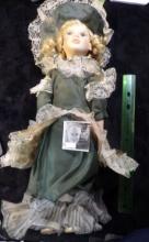 Lovely Blounde-haired female Doll with lace Dress and hat, on stand. A little over 16" in height.