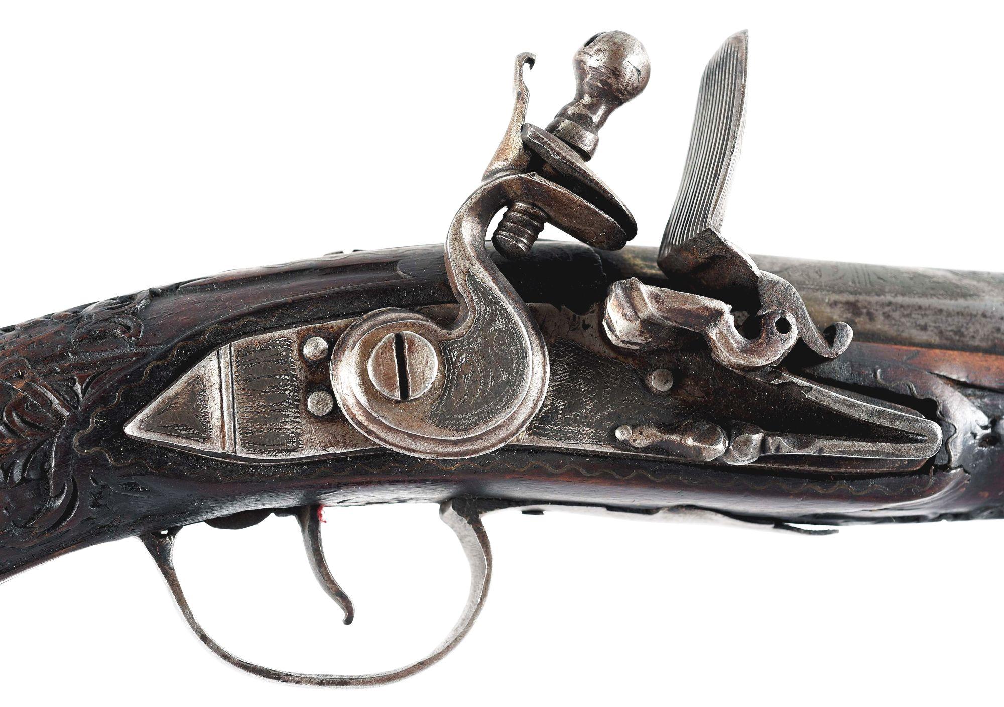 (A) HIGHLY DECORATED OTTOMAN FLINTLOCK KNEE GUN, WITH EXTENSIVE CARVING AND SILVER WIRE INLAY.