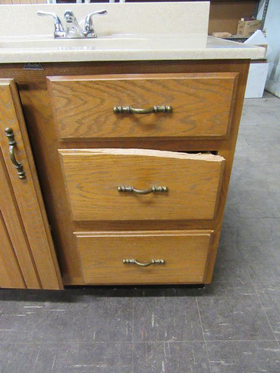 BATHROOM SINK WITH FIXTURE AND CABINET. DRAWER NEEDS REPAIRED.