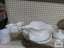 Assorted milk glass items including centerpiece dish, mug, creamer, covered candy dish