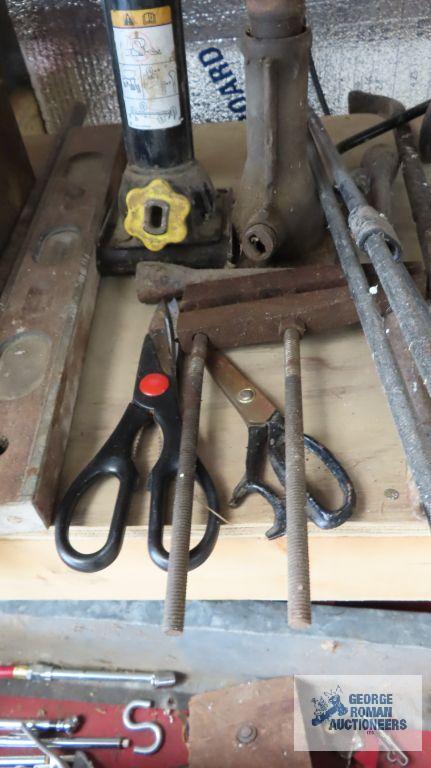 vintage braces, bottle jacks, vintage wooden level, etc under bench