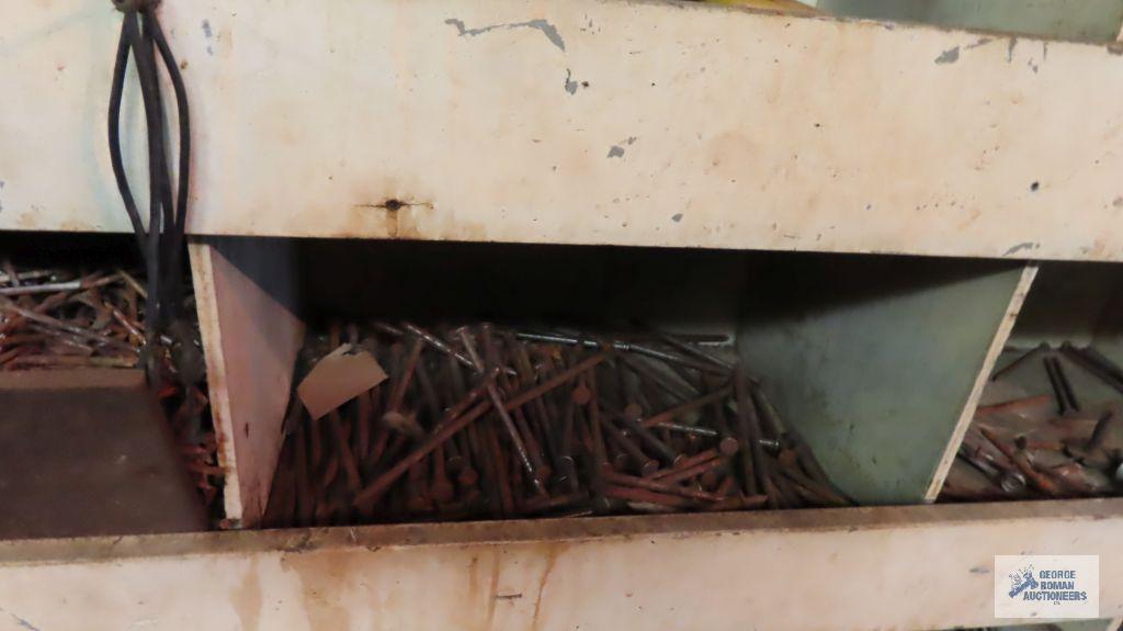 Large amount of hardware in bins and horseshoe wall hanging. Wooden bins stay with the house.