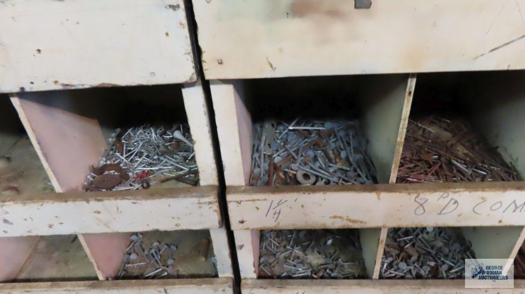 Large amount of hardware in bins and horseshoe wall hanging. Wooden bins stay with the house.