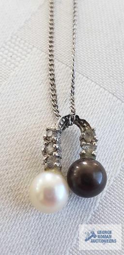 Two pearl like beads with clear gemstone charm on silver colored chain, chain marked 925 and other