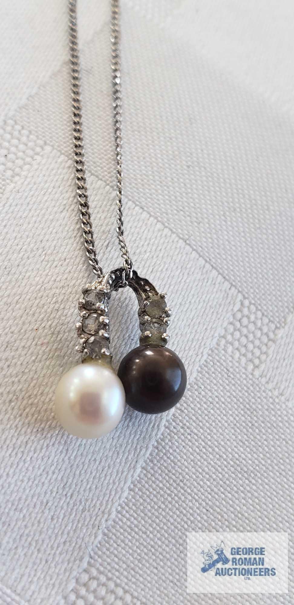 Two pearl like beads with clear gemstone charm on silver colored chain, chain marked 925 and other