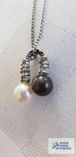 Two pearl like beads with clear gemstone charm on silver colored chain, chain marked 925 and other