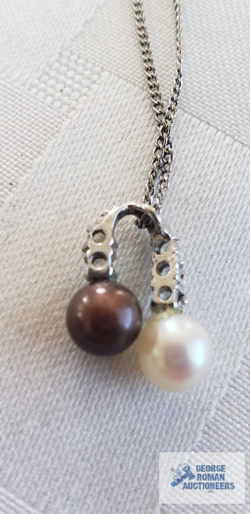 Two pearl like beads with clear gemstone charm on silver colored chain, chain marked 925 and other