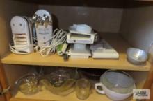 Cupboard lot of hand mixers and assorted mixing bowls