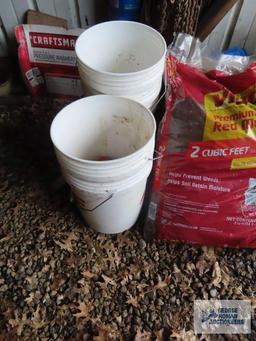 Lot of mulch, plastic buckets, wooden crate, fence post and etc