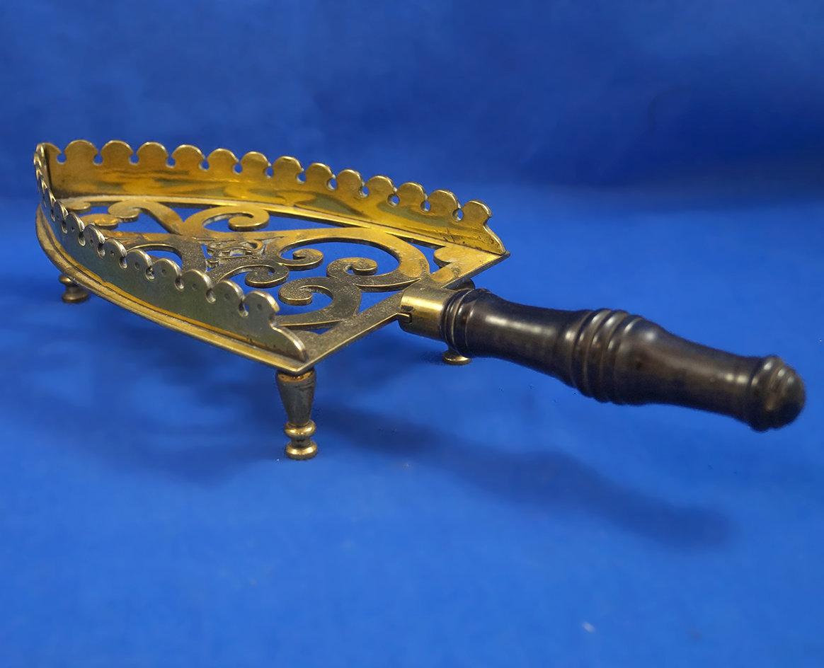Brass iron rest, raised sides, ornamental, black wood handle, 11 1/2" long