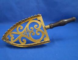 Brass iron rest, raised sides, ornamental, black wood handle, 11 1/2" long