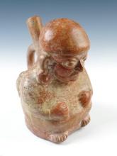 7" tall Moche II - III Seated Human Effigy Bottle depicting a man with ear plugs and bag.