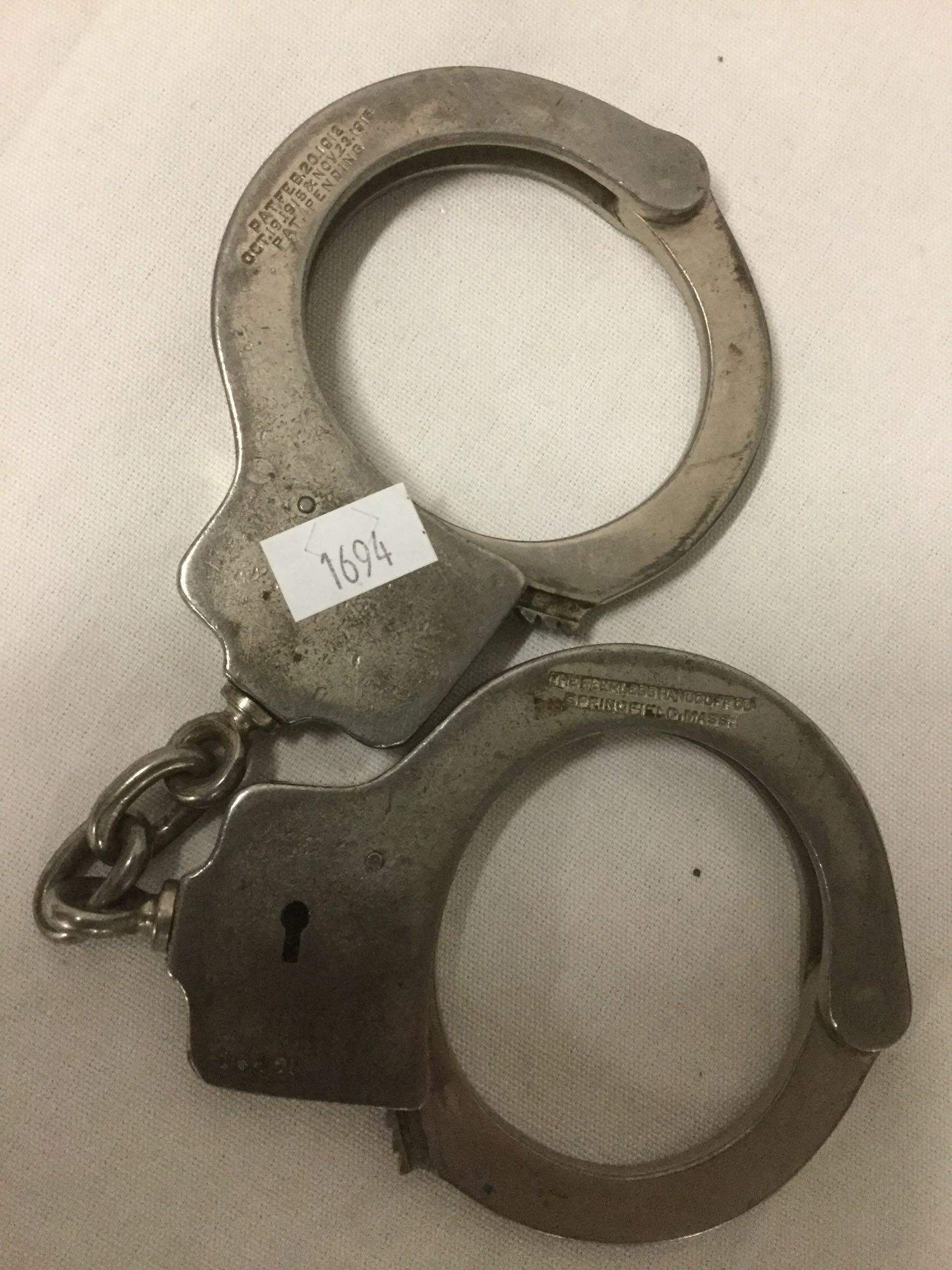 3 law enforcement items - Argus MFG The Iron Claw wrist cuff, 1912 Peerless hand cuffs + nightstick