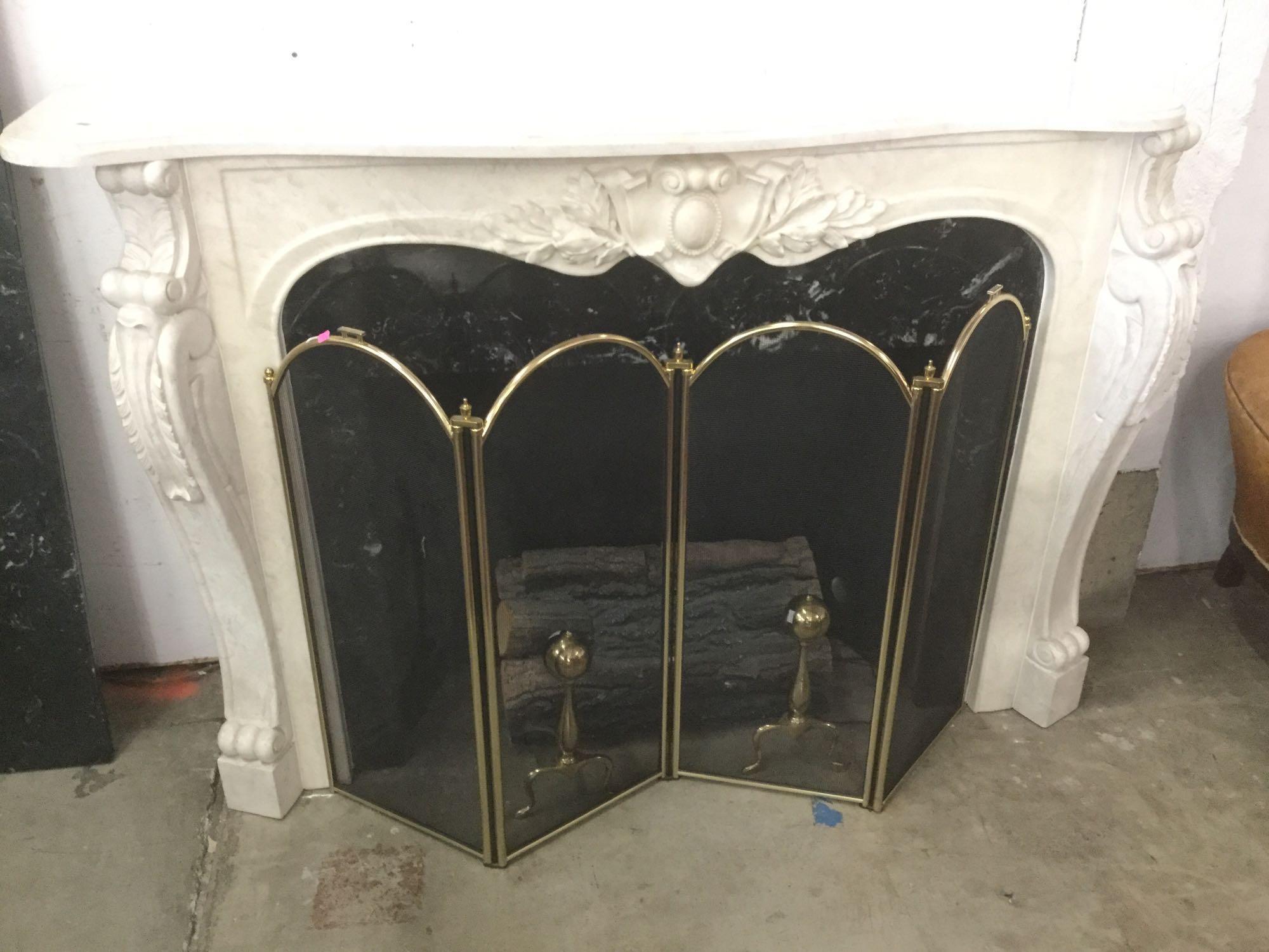 Decorative marble top electric fireplace with ornate mantle and brass screen