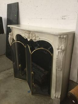 Decorative marble top electric fireplace with ornate mantle and brass screen