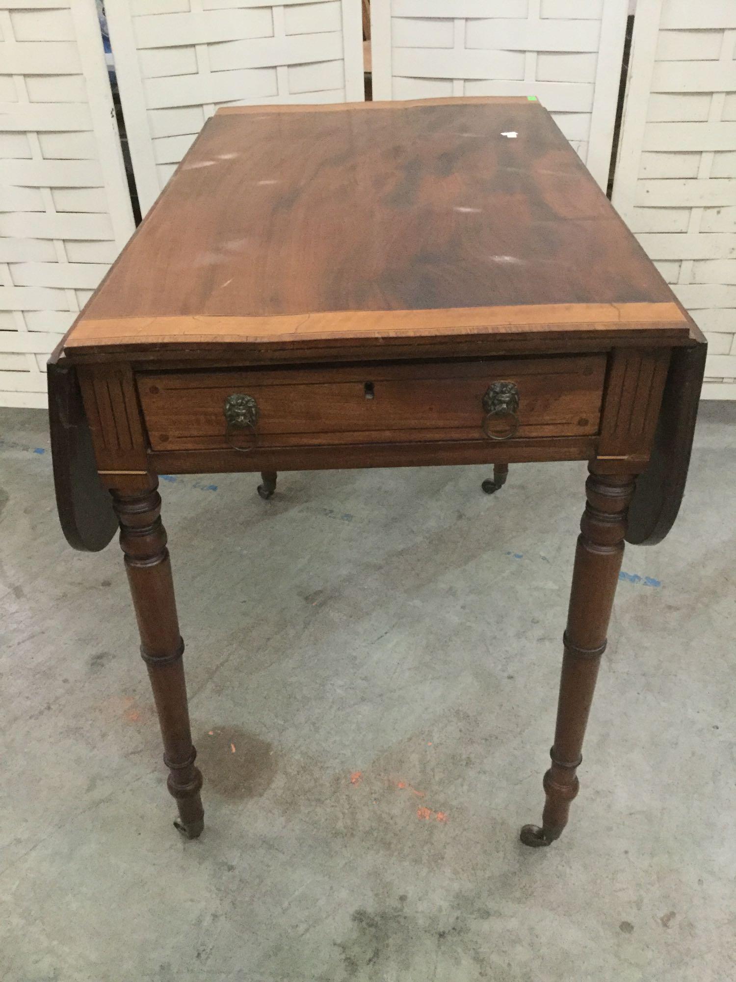 Antique drop leaf side table with drawer, lion head drawer pulls, and casters