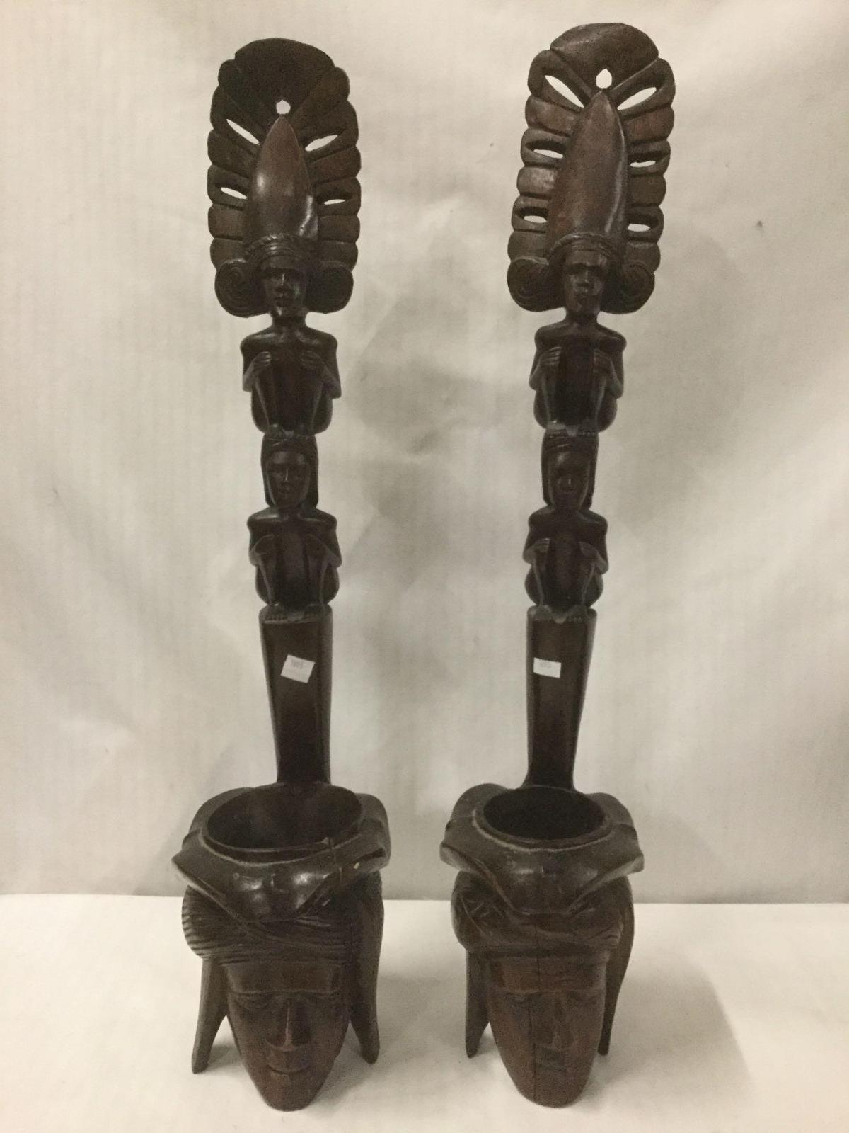 Pair of ornate Indonesian/Islander carved male/female head and totem style figures