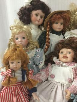 Fourteen porcelain and composite dolls from makers like Swan Collection. Largest doll is approx.