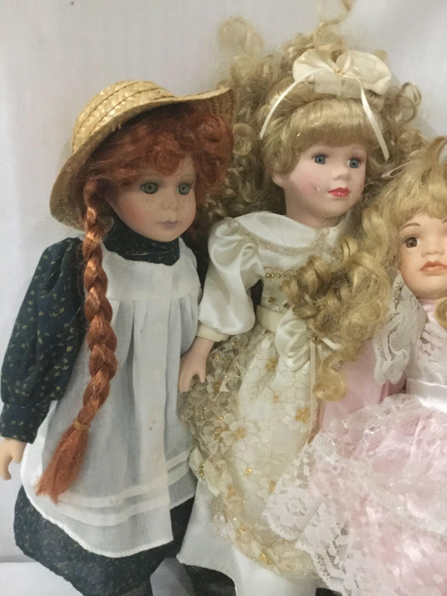 Fourteen porcelain and composite dolls from makers like Swan Collection. Largest doll is approx.