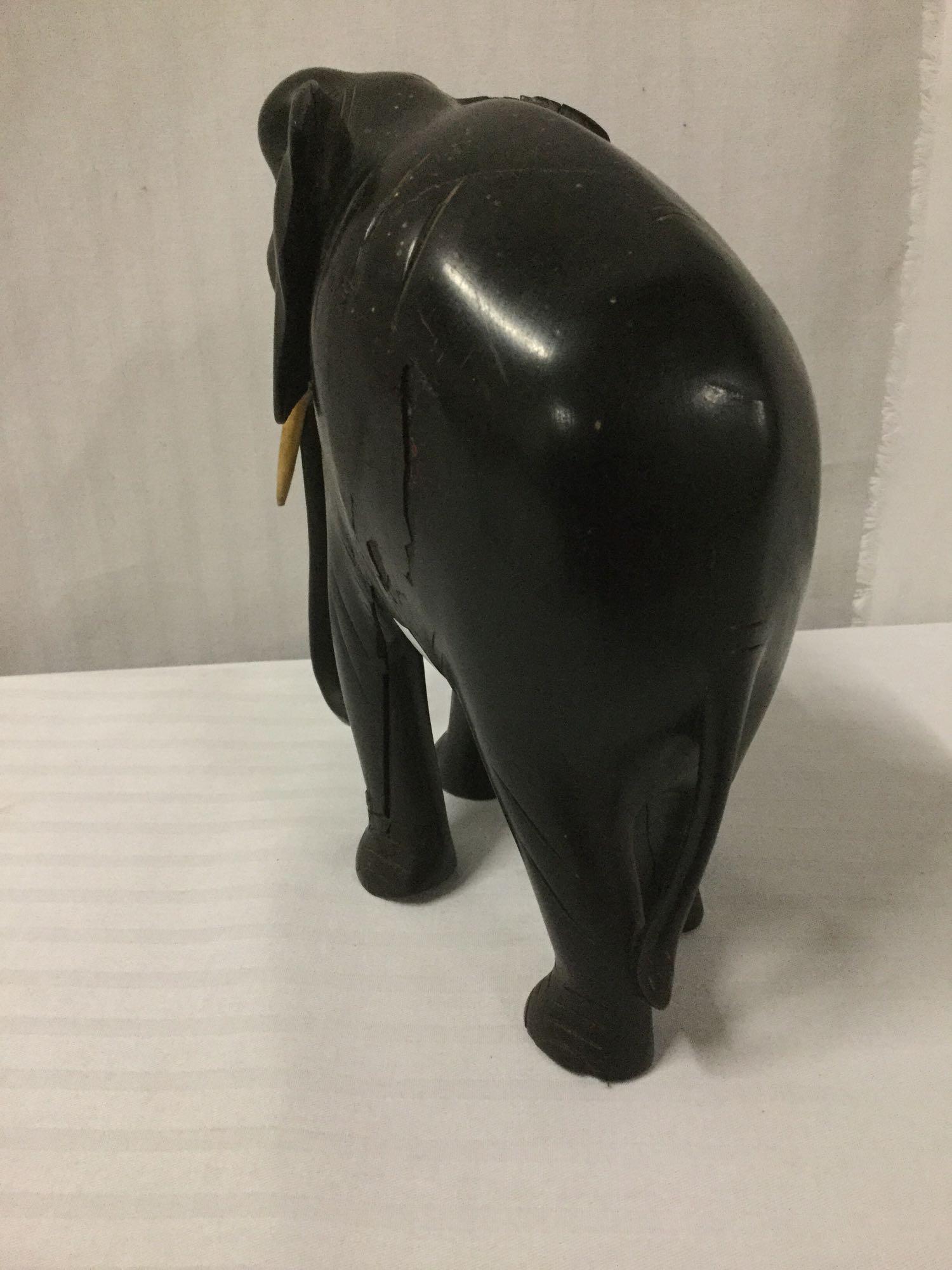 Ironwood carved elephant statue with bone tusks - body of the statue shows damage as is