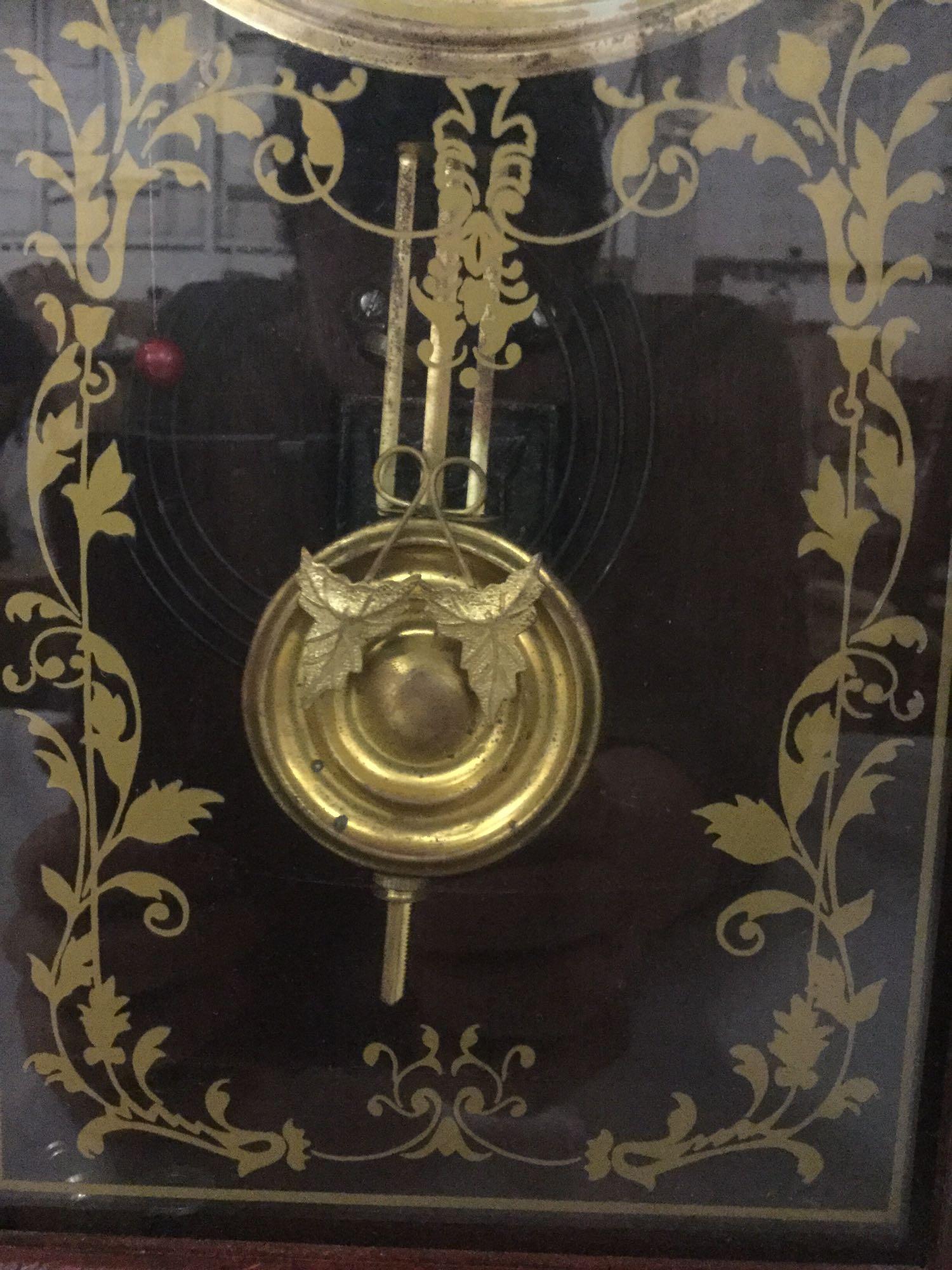 Antique time strike mantle clock with unique molding, floral design glass front & has pendulum/key