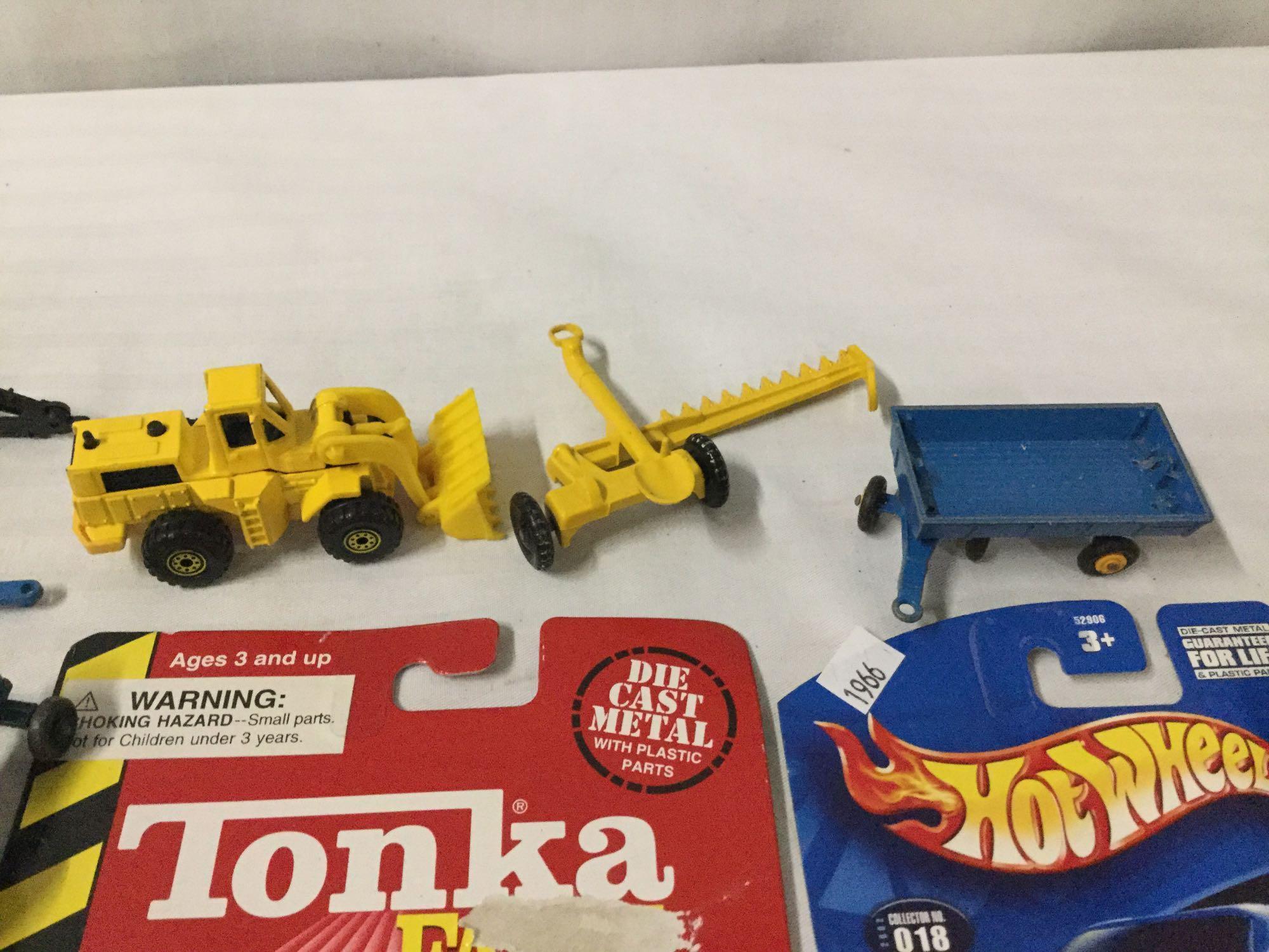 Collection of vintage and modern die cast and plastic cars and farm equipment.