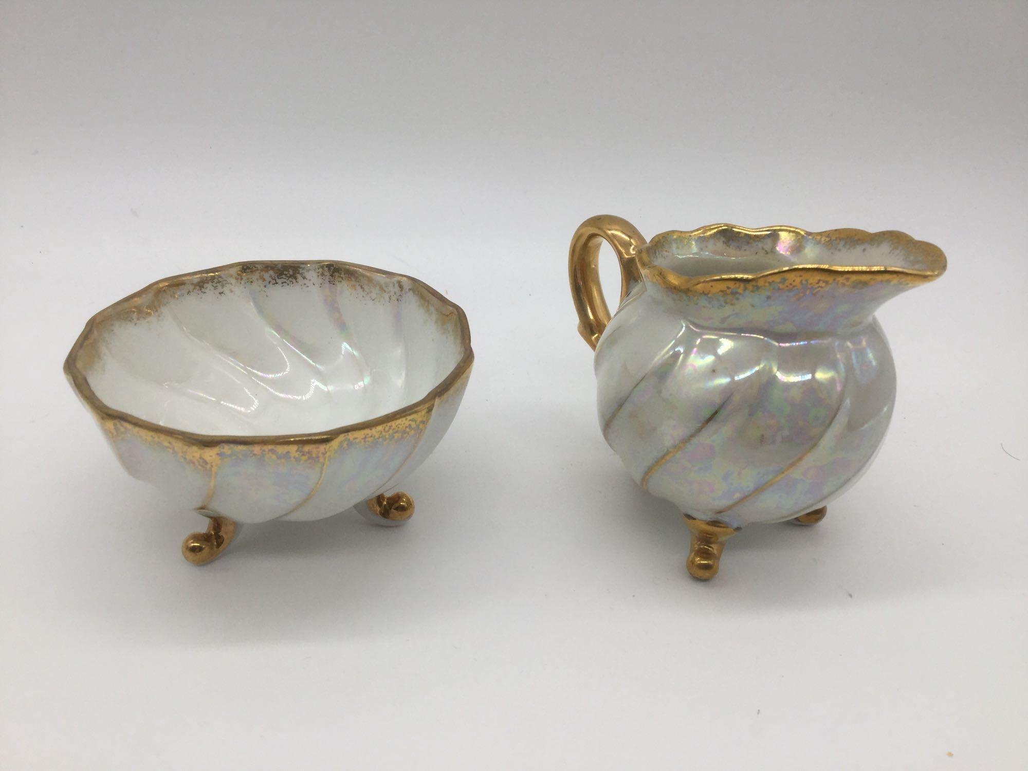 4 Japanese China items: saucer w/ gold tone trim, soup spoon, & opalescent creamer & sugar bowl.