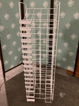 White metal wire retail paper rack, approx. 12 x 12 x 42 inches.