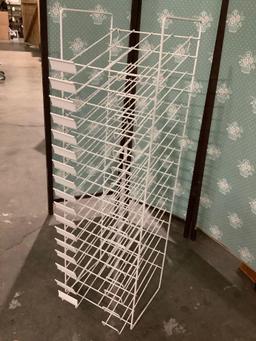 White metal wire retail paper rack, approx. 12 x 12 x 42 inches.