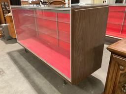 Large vintage standing glass display case, back loading, with two glass shelves. Glass top has